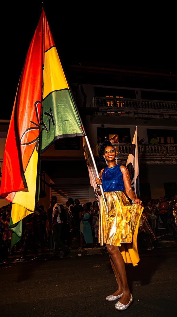 RGR SHOOT, porte-drapeau en costume doré dans un défilé de rue
